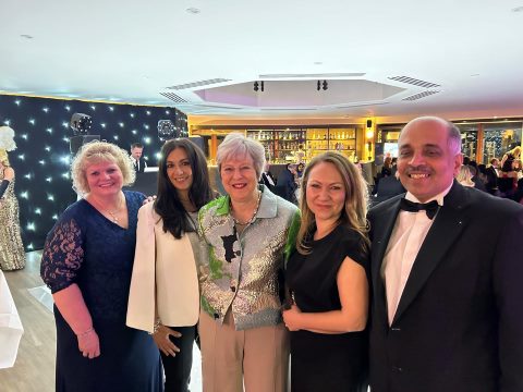Liz, Emma, Marianna and Rakesh flanking Theresa May at the event, all in evening wear.