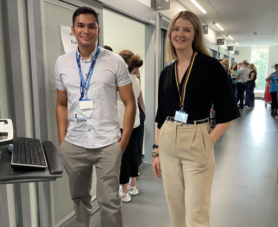 Two doctors stood at a computer workstation in hospital corridor