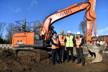 Left to right: Mayor Dhillon of Slough, MP of Slough Tan Dhesi, Health, James Clarke, Chief Strategy Officer Frimley Health and Lance McCarthy, Chief Executive Frimley Health posing in front of a digger