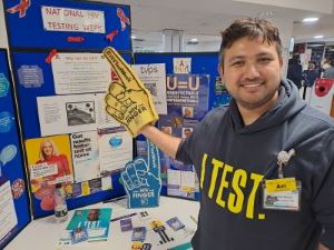 Avi Khanal, HIV surveillance clinical nurse specialist for Frimley Health, with the public display.